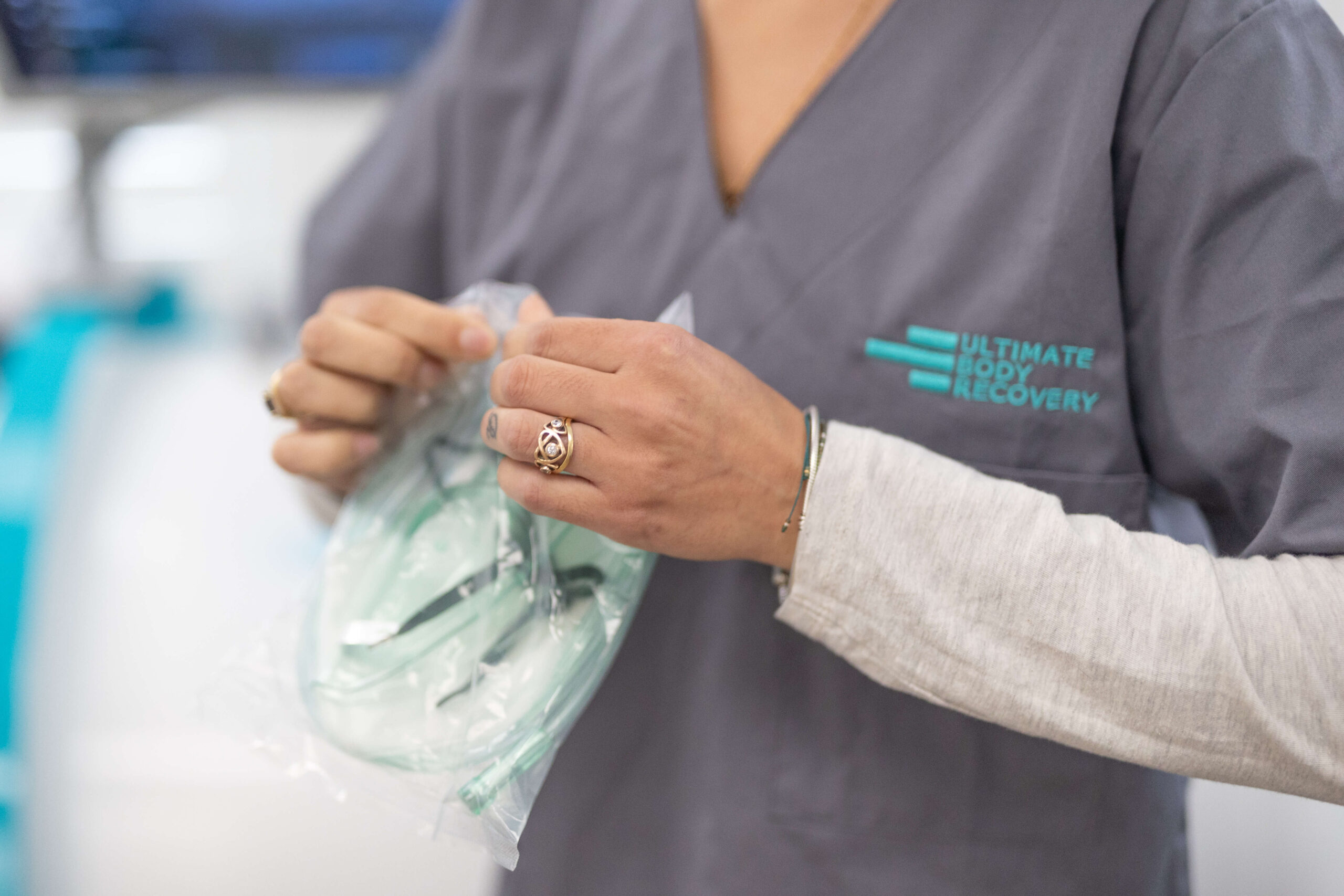 Technician at Ultimate Body Recovery holding equipment for Hyperbaric Oxygen Therapy.